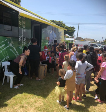 mobile library bus with children waiting outside