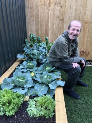 Man sitting on a vegetable garden box